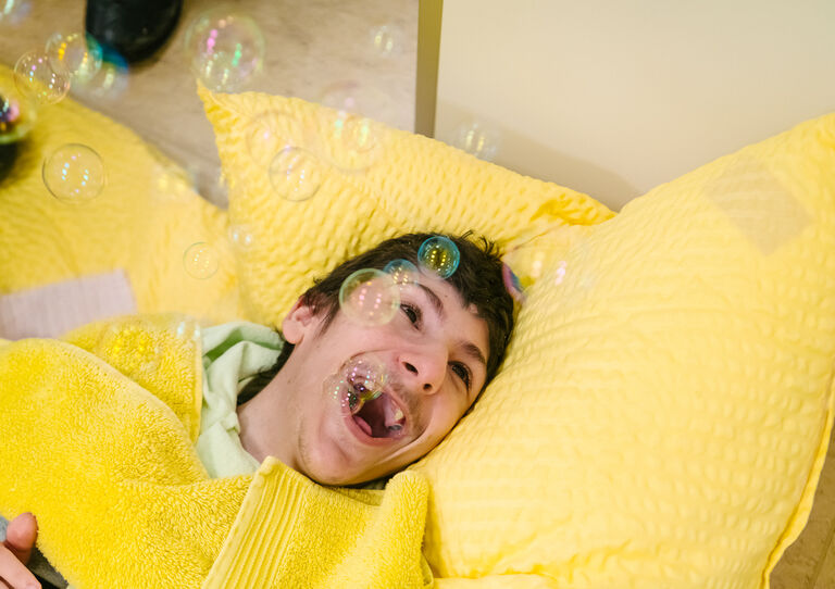 Ein Kind der HABIT Kids WG freut sich über Seifenblasen.