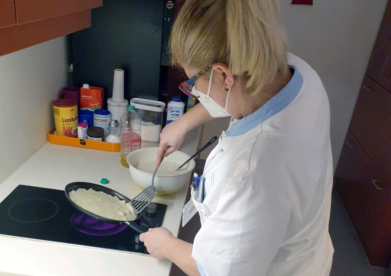 Eine Mitarbeiterin macht Palatschinken für die Kolleginnen der Nachbarstation