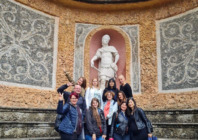 Kolleg*innen aus dem HB Seeböckgasse stehen zusammen vor einem Brunnen in Salzburg.