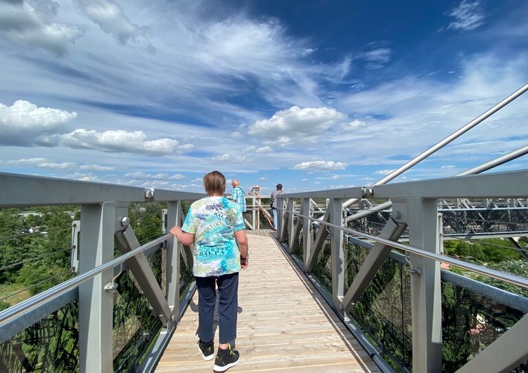Eine Bewohnerin von hinten, die über eine Brücke geht.