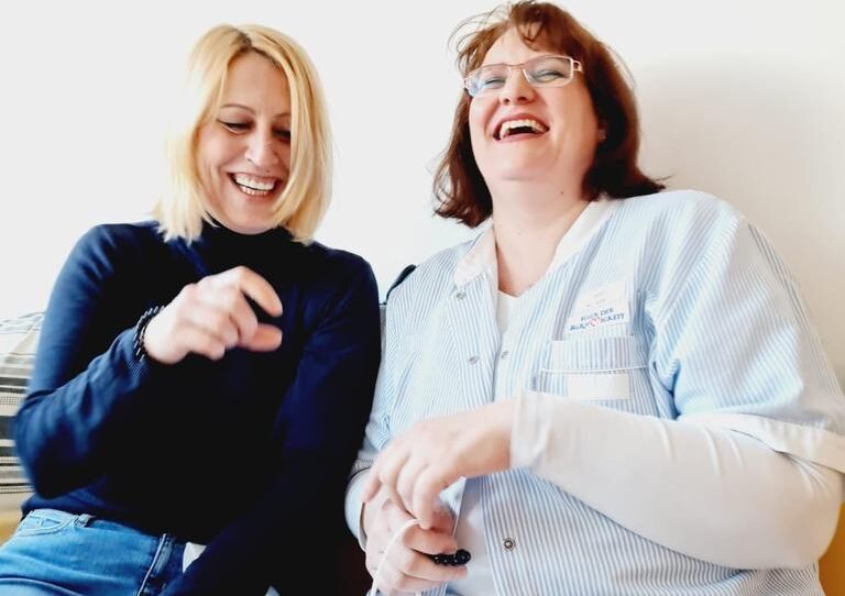 Zwei Kolleginnen lachen miteinander