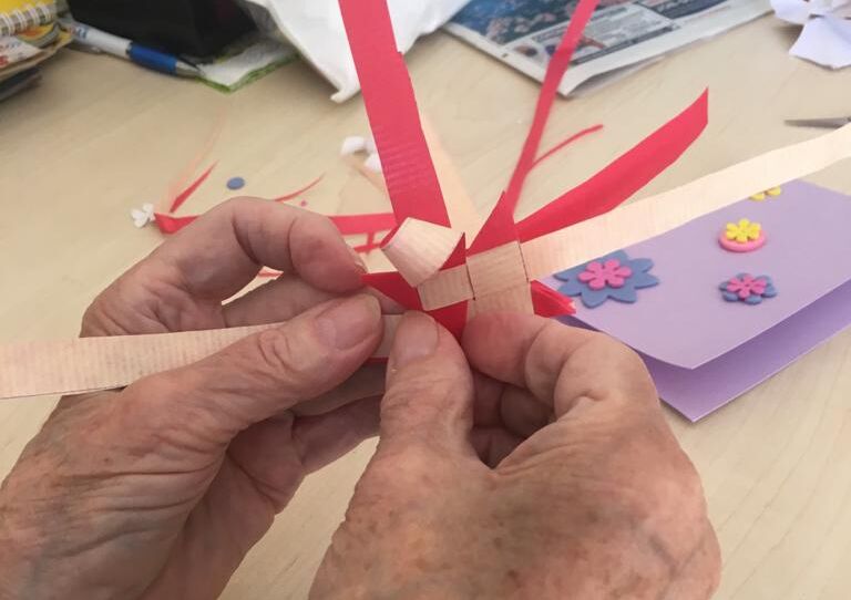 Die Hände einer Bewohnerin beim Basteln.