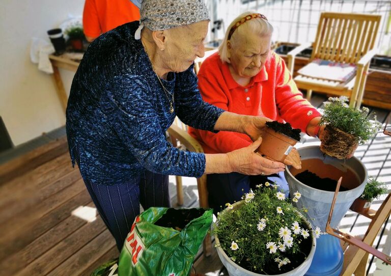 Den Bewohnerinnen macht das Pflanzen der Blumen viel Spaß.