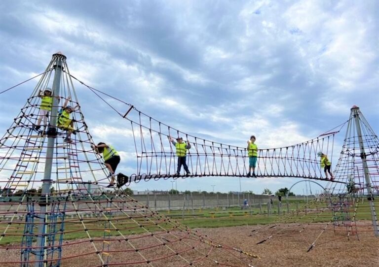 Kinder auf einem Klettergerüst im Motorikpark.
