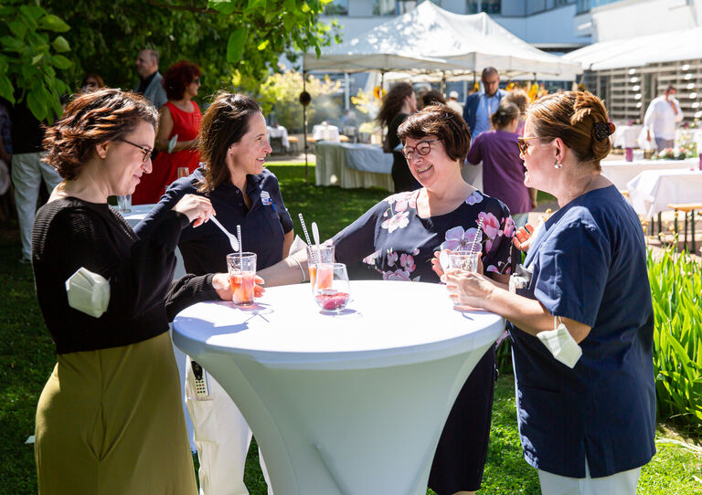 Mitarbeiter*innen stoßen gemeinsam an.