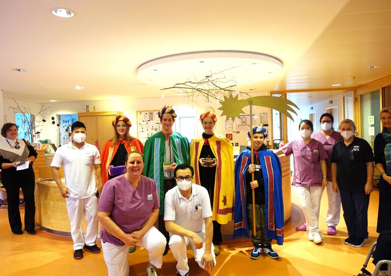 Sternsinger*innen besuchen das Haus der Barmherzigkeit Tokiostraße und haben sich mit Mitarbeiter*innen aus dem HB zu einem Gruppenfoto formiert