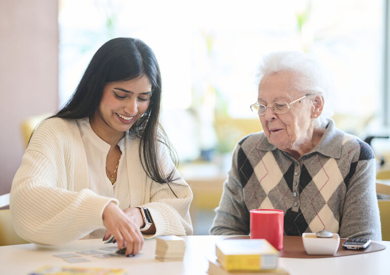Eine Studentin spielt Memory mit einer Bewohnerin. Eine Studentin spielt Memory mit einer Bewohnerin.