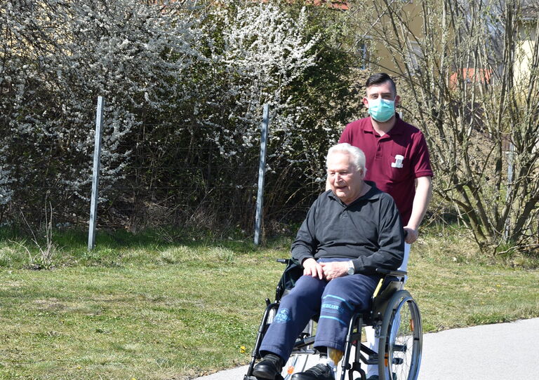 Bewohner und Pfleger auf der sonnigen Terrasse