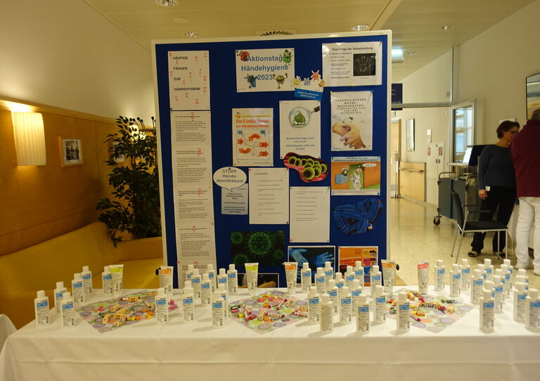 Bild von kleinen Desinfektionsfläschchen und einer Transparentwand.