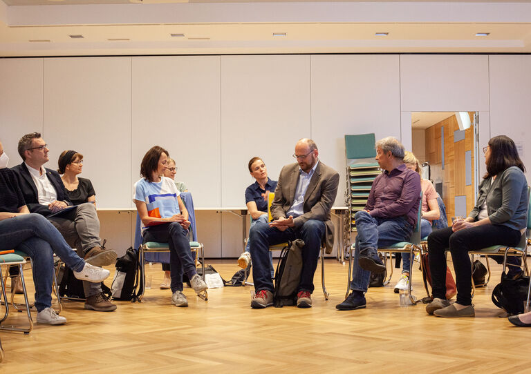 Teilnehmer*innen des QM Dialogs lauschen der Vortragenden.