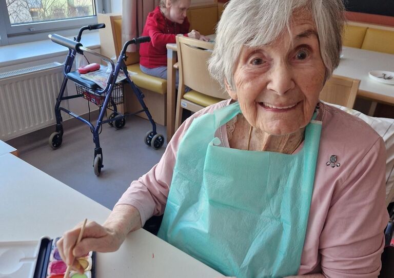 Bewohnerin zeigt selbst bemalten Tonhasen in die Kamera