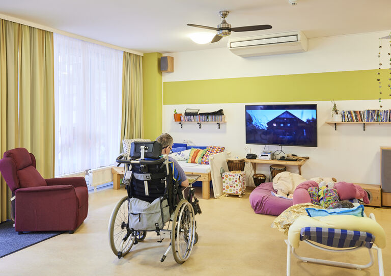 2 Kund*innen sehen fern im Wohnzimmer der HABIT WG 1 Clementinum