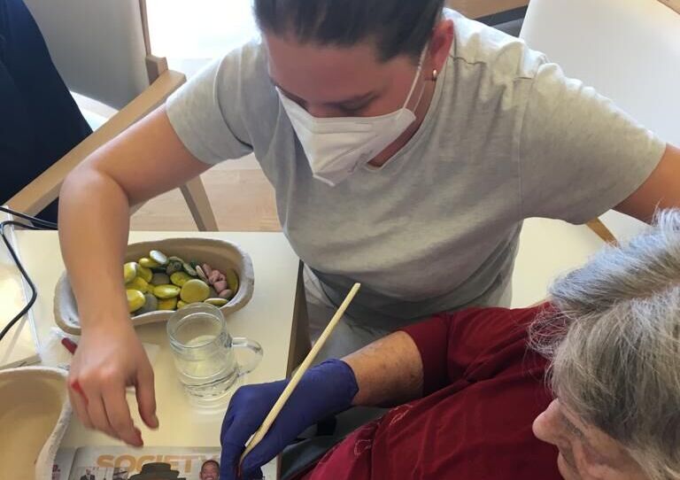 Bewohnerinnen und Mitarbeiter*innen basteln an den Kunstwerken.