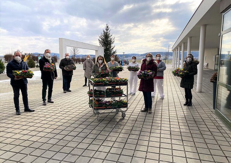 Die Mitarbeiter*innen mit der Blumenspende vor dem Heim.