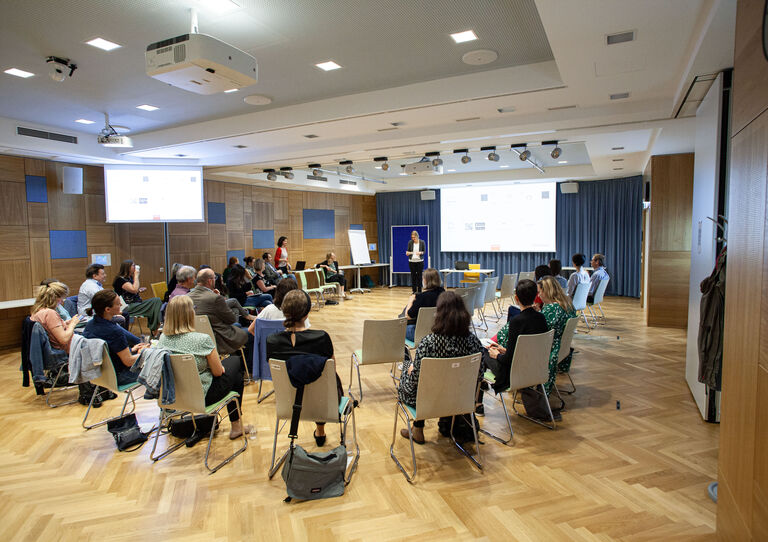 Teilnehmer*innen des QM Dialogs lauschen der Vortragenden.