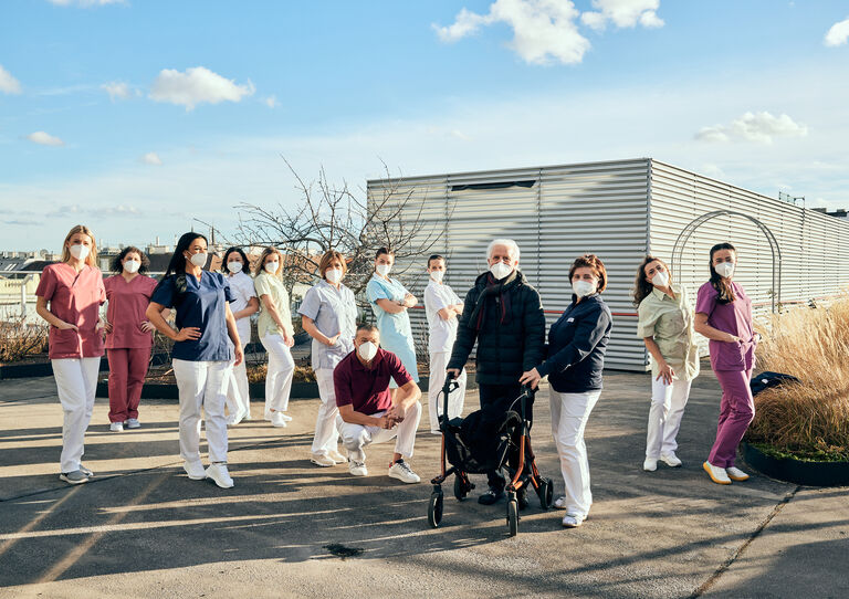 Die Mitarbeiter*innen präsentieren die neuen Kleidungsstücke auf der Dachterrasse.