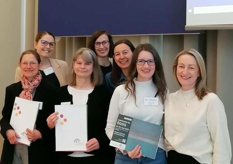 Einige Kolleginnen stehen mit einer Urkunde in den Händen zusammen.