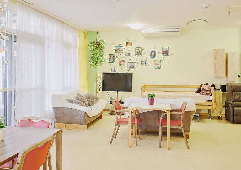 Wohnzimmer der HABIT WG 2 Clementinum mit Sofa, Bett und Esstischen