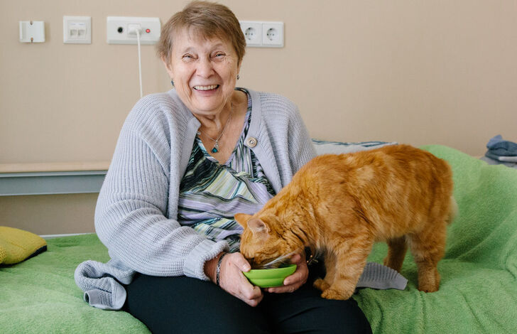 Bewohnerin Maria füttert Kater Stephan.