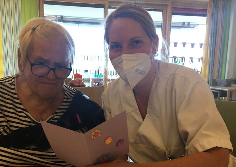 Praktikantin Eva liest die Karte gemeinsam mit einer Bewohnerin.