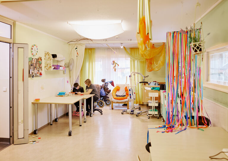 BTZ Maria-Rekker-Gasse: Aufnahme des Raums: Kunde und Mitarbeiterin basteln miteinander.