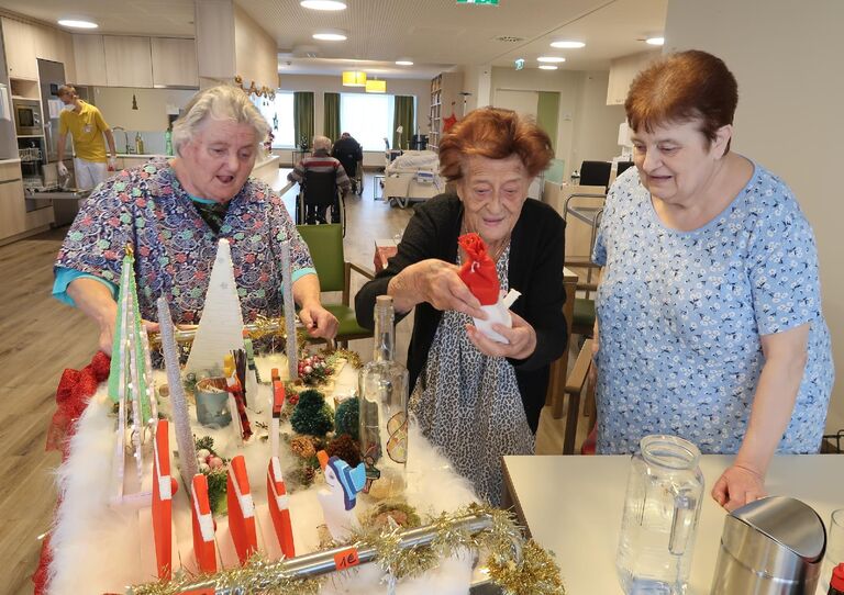 Vier Bewohnerinnen sehen sich dem mobilen Weihnachtswagen an.