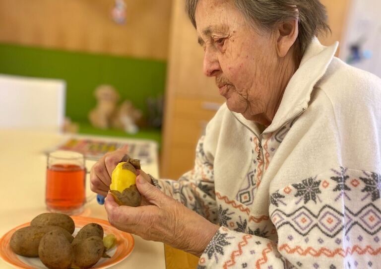 Bewohnerin schält Kartoffel