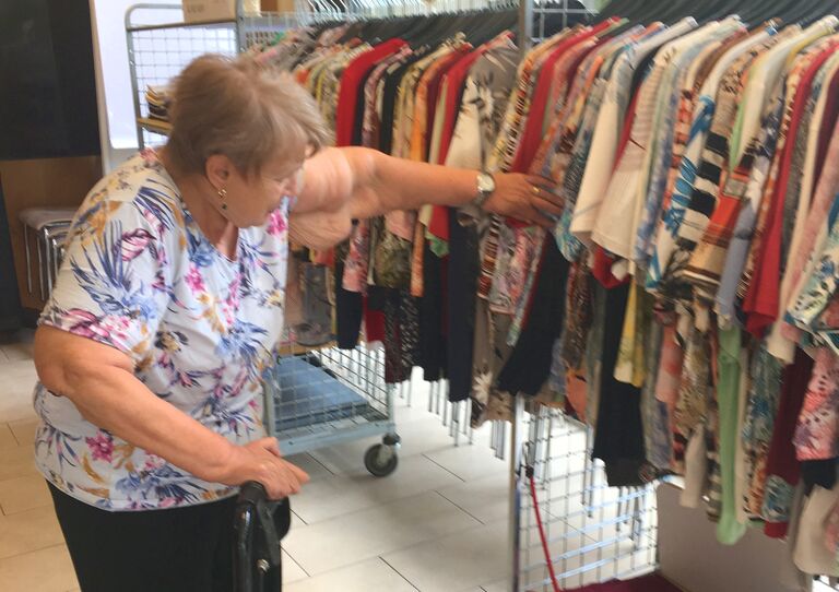 Bewohnerin stöbert durch verschiedene Kleidungsstücke