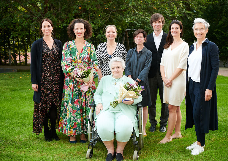 Gruppenbild von allen Teilnehmer*innen der Podiumsdiskussion sowie den beiden Künstler*innen.