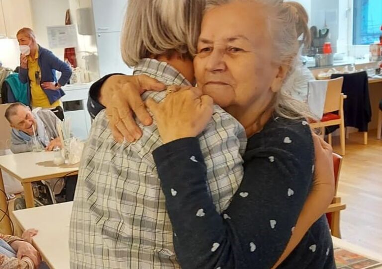 Mitarbeiterin Petra tanzt mit einer Bewohnerin.