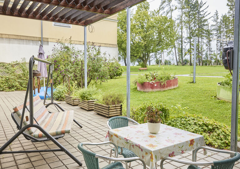 Terrasse der HABIT WG 1 Clementinum mit Hollywood-Schaukel, offen zur Grünfläche des Gartens