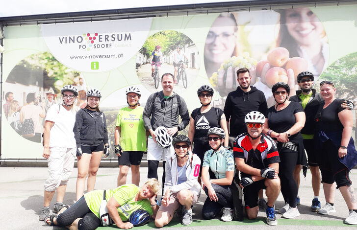 Kolleg*innen stehen für ein Gruppenbild zusammen. Sie haben Fahrradklamotten an.