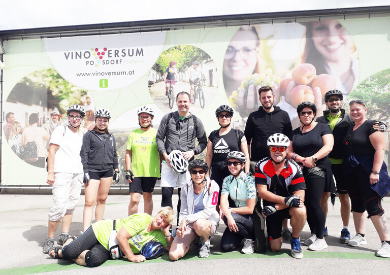 Mitarbeiter*innen aus dem Urbanusheim in Fahrradmontur stehen für ein Gruppenbild zusammen.