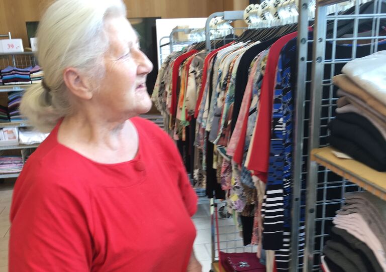 Bewohnerin begutachtet die Kleiderauswahl.