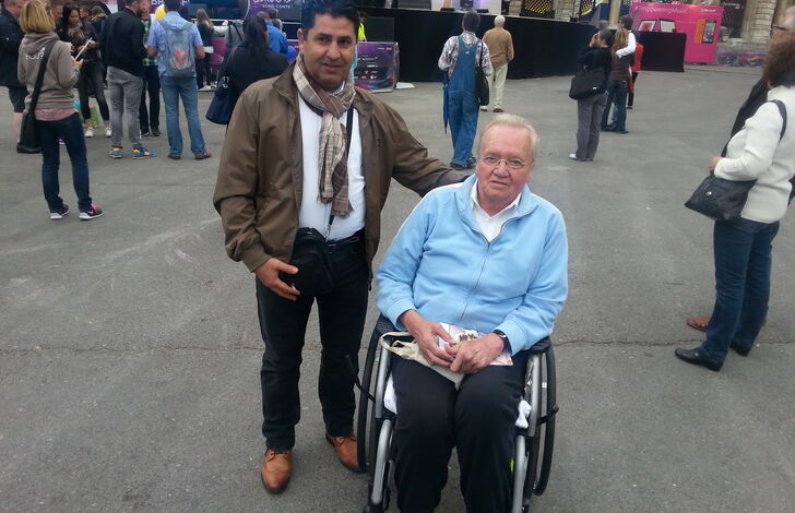 Birkent Zeynel und ein Bewohner im Rollstuhl, sie besuchen ein Open Air Konzert.