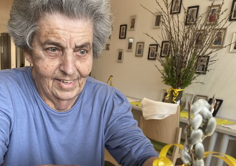 Eine Bewohnerin bastelt an einem Palmbuschen.