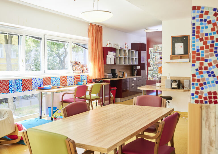Heller Wohnraum mit Essbereich und Küche mit bunten Fliesen an den Wänden in der HABIT WG Schanzstraße