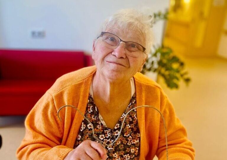 Bewohnerin modelliert Kleiderbügel.