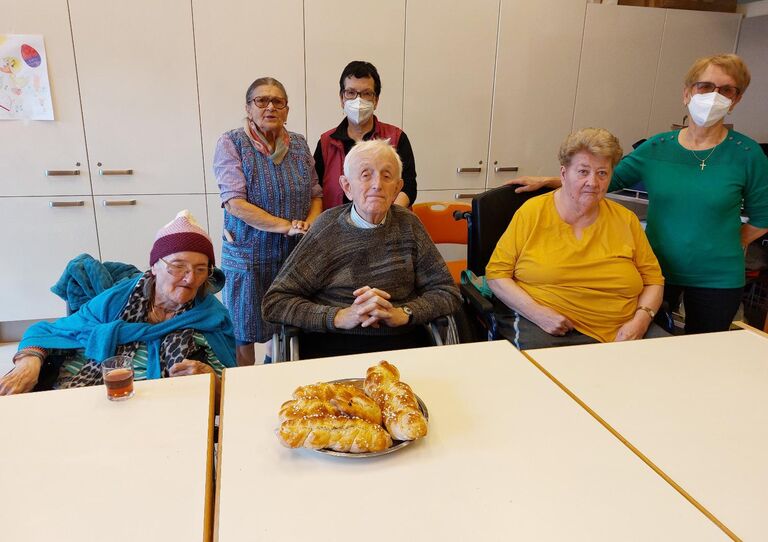 Einige Bewohner*innen präsentieren ihren Osterstriezel und posieren für ein Gruppenfoto.