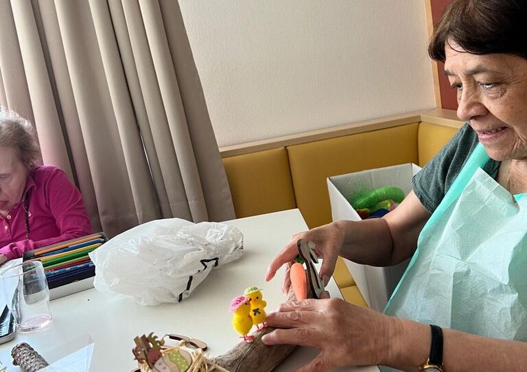 Bewohnerin bastelt ein Ostergesteck