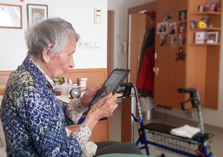Eine Bewohnerin unterhält sich via Tablet mit Angehörigen