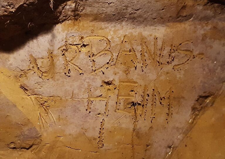 Mitarbeiter*innen verewigen sich im Löss mit dem Schriftzug "Urbanusheim"