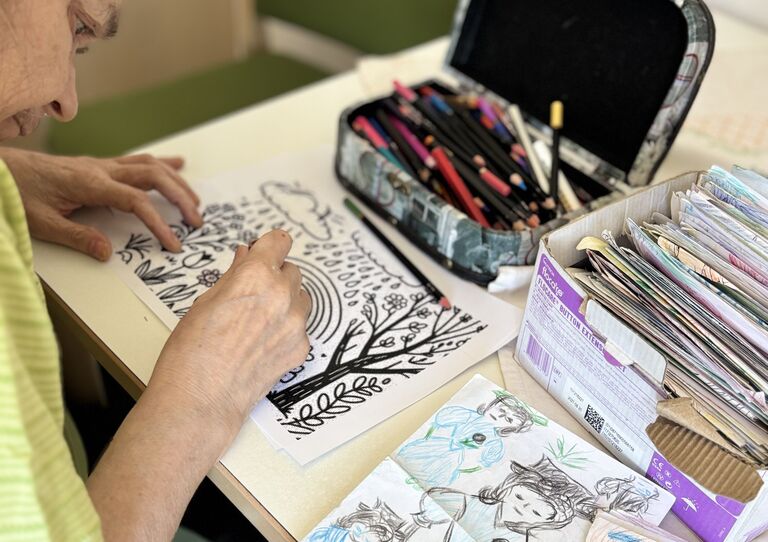 Gemeinsam mit den Bewohner*innen werden im Urbanusheim "Vergissmeinnicht"-Schachteln für die Angehörigen gebastelt