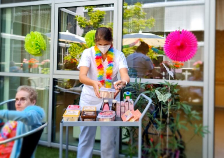 Mitarbeiterin bereitet am Eiswagen ein Eis vor