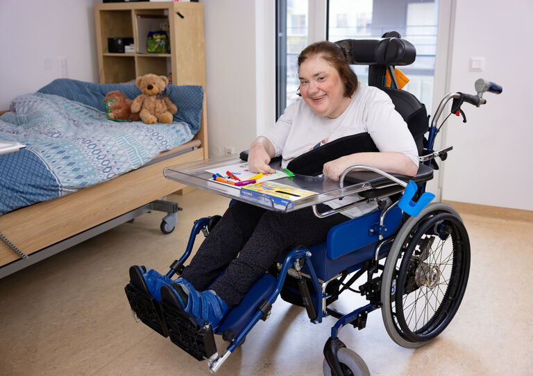 HABIT Kundin im Rollstuhl lächelnd.