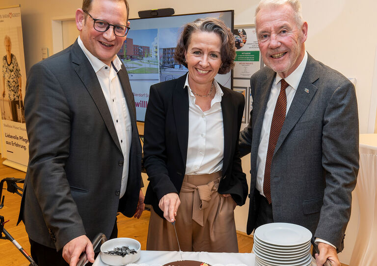 Heimleiter und Geschäftsführer Lukas Pohl, Elke Schmid-Dierdorf und Bürgermeister Klaus Schneeberger beim Anschneiden der Geburtstagstorte