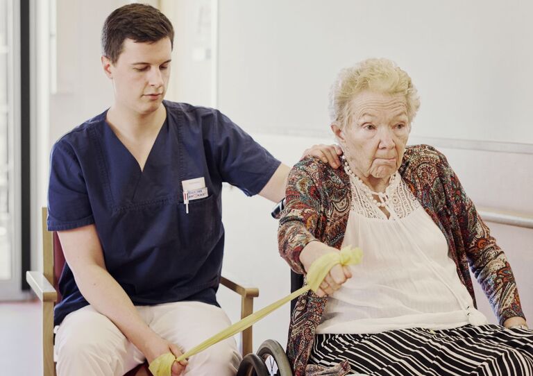 Tristan Tomann, Therapeut im HB Pflegekrankenhaus Tokiostraße, mit unserer Bewohnerin Gitta Tristan Tomann, Therapeut im HB Pflegekrankenhaus Tokiostraße, mit unserer Bewohnerin Gitta