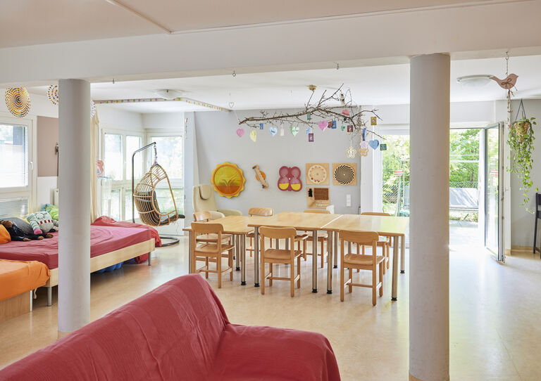 großes, helles Wohnzimmer der WG Otto-Herschmann-Gasse mit Sofas und Esstisch