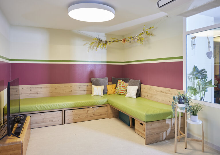 Fernsehecke der HABIT WG Arndtstraße mit Sitzbank mit grünem Polster