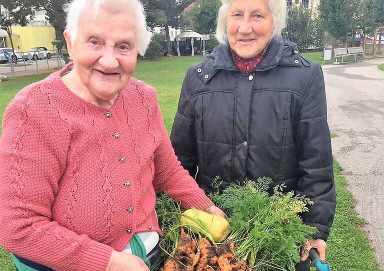 Zwei Bewohnerinnen mit der geernteten Ausbeute.